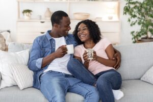 couple-sitting-on-couch-enjoying-their-home