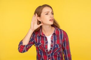 Woman-holding-hand-to-ear-to-listen