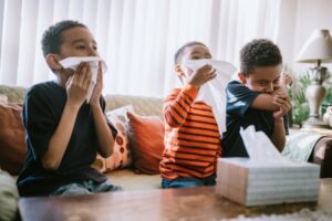 three-young-boys-on-couch-sneezing-and-blowing-nose