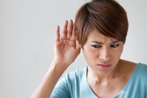 woman-holding-hand-to-ear-trying-to-listen